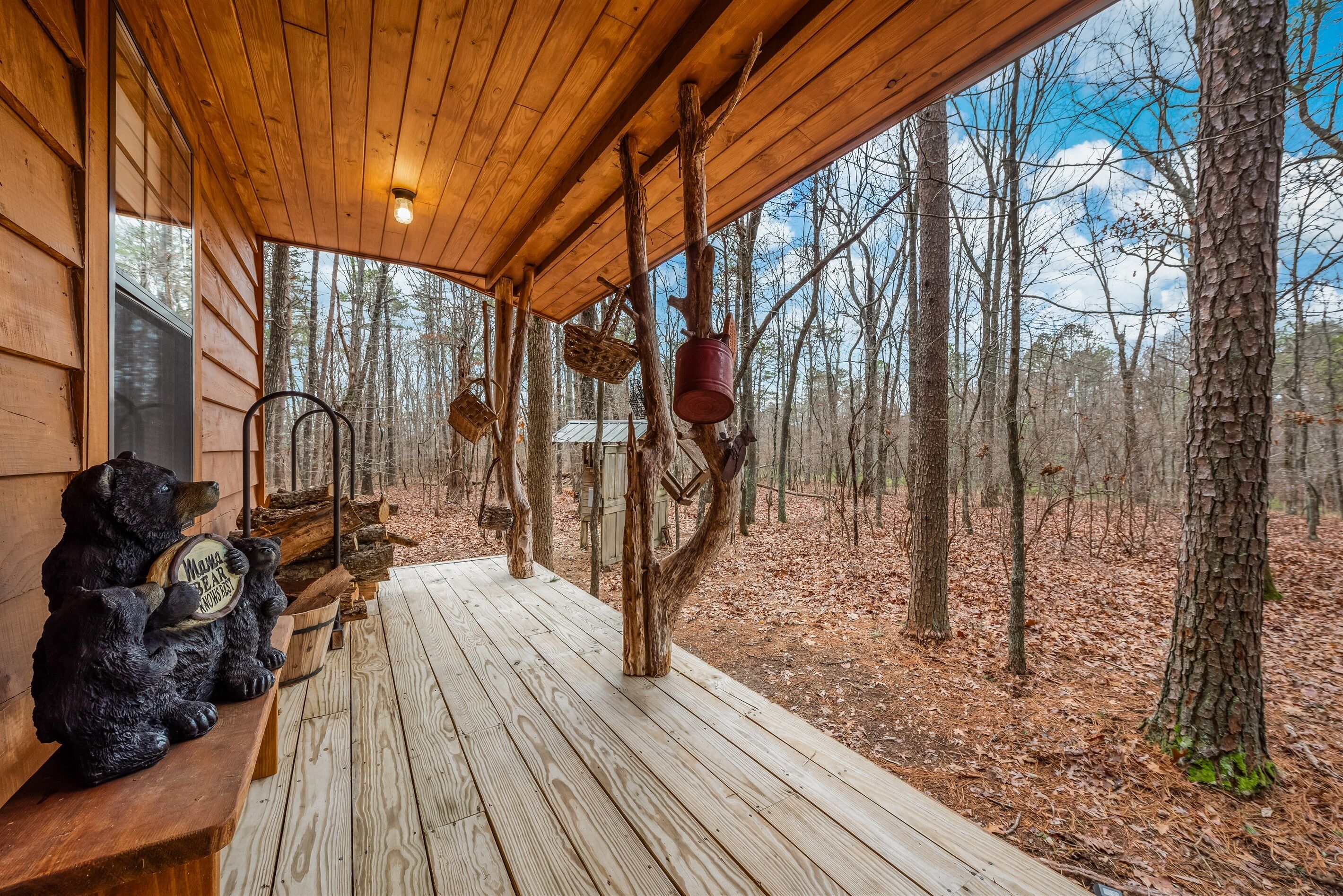 A wooden cabin with a porch, rustic decor, and a forest view.