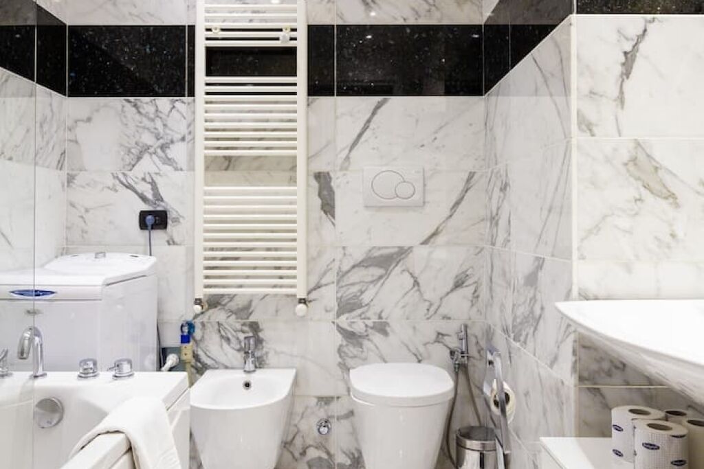 Een moderne badkamer met een wit wastafel, meubel en bad.
