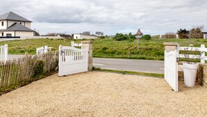A gated driveway leading to a residential area with houses and a road. - Galv Ar Mor, Petite Maison Cosy Proche Plage (Cléder)
