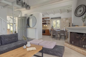 A spacious living area with a grey sofa, a wooden coffee table, and a fireplace.