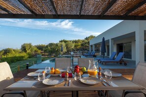 Enjoy breakfast in style with a beautifully set table amidst a serene poolside setting.