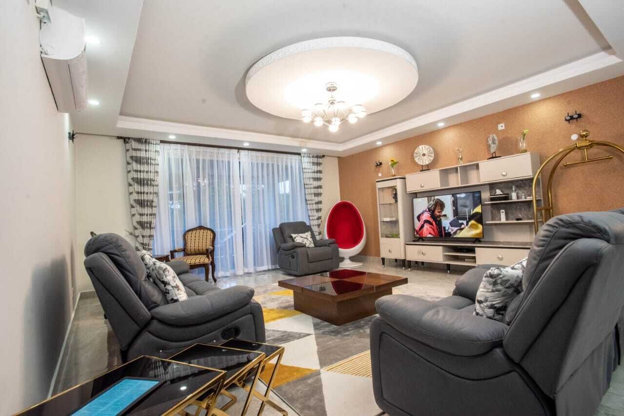 Una sala moderna con un juego de sofá, una mesa de centro y un televisor.