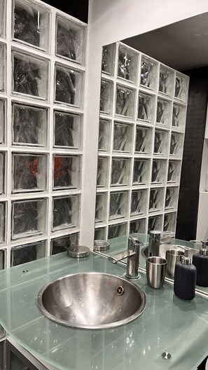 A bathroom with a glass sink, stainless steel fixtures, and a tiled wall with a marble-like pattern. - Wonderful and rare house with garden - Ideal for Paris OG 2024 ! (Ivry-sur-Seine)
