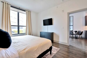 Relax in a spacious room with a large bed, flat-screen TV, and dining area.