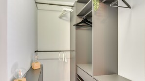 Un dressing avec une tringle à vêtements, des étagères et un porte-chaussures.