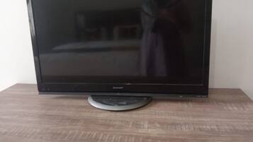 A flat-screen TV on a wooden table.