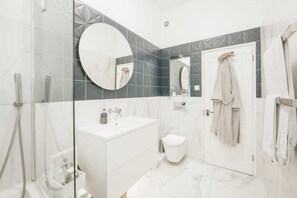 Eenvoudig appartement | Badkamer | Een douche, handdoeken, zeep, shampoo