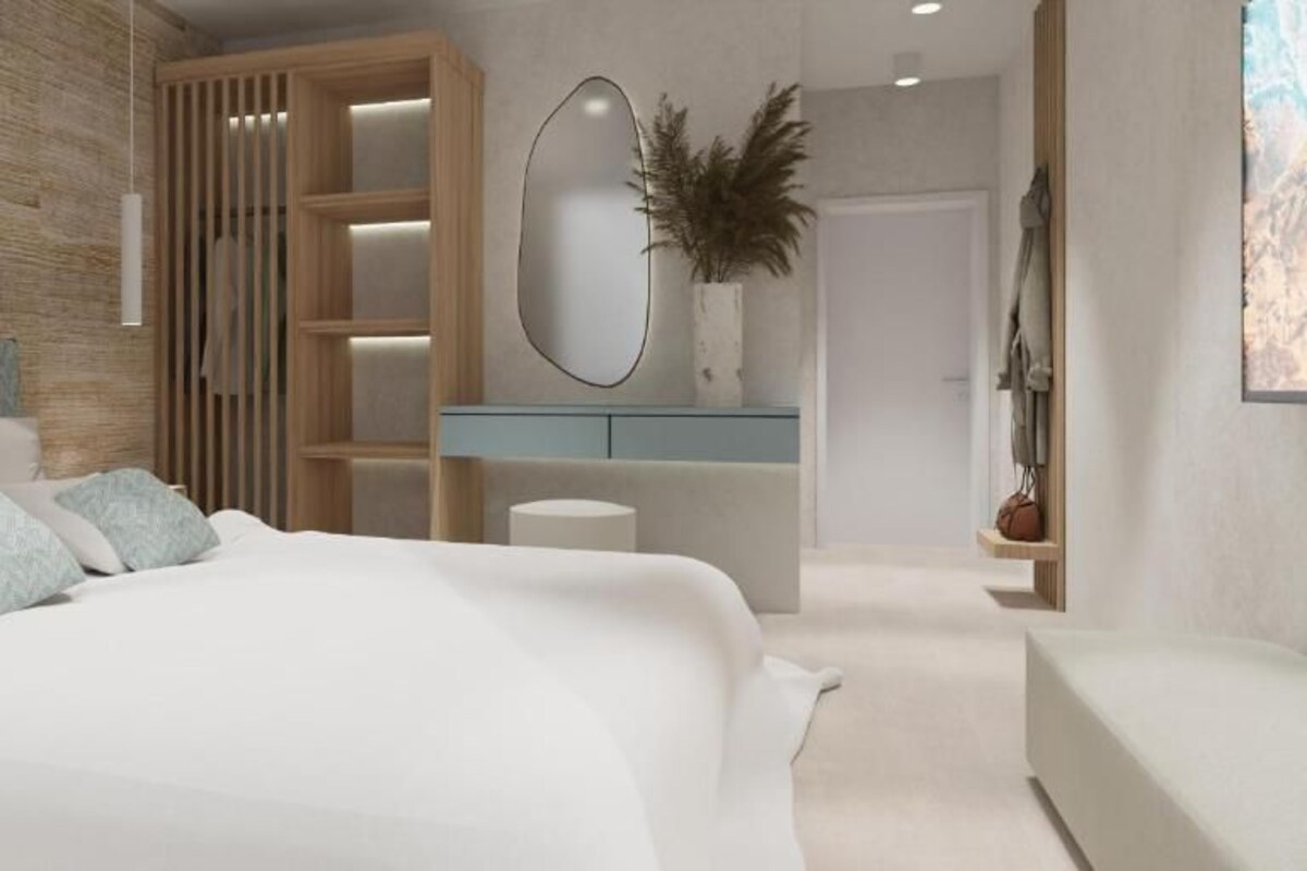 A modern bedroom with a large bed, a wooden wardrobe, a mirror, and a small table.