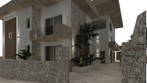 Un hotel moderno con fachada de piedra, varios balcones y un vestíbulo espacioso.
