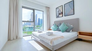 Habitación de hotel moderna con una cama grande, vista a la ciudad y decoración minimalista.