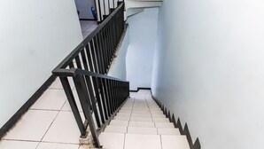 A staircase with a black railing and white tiles.
