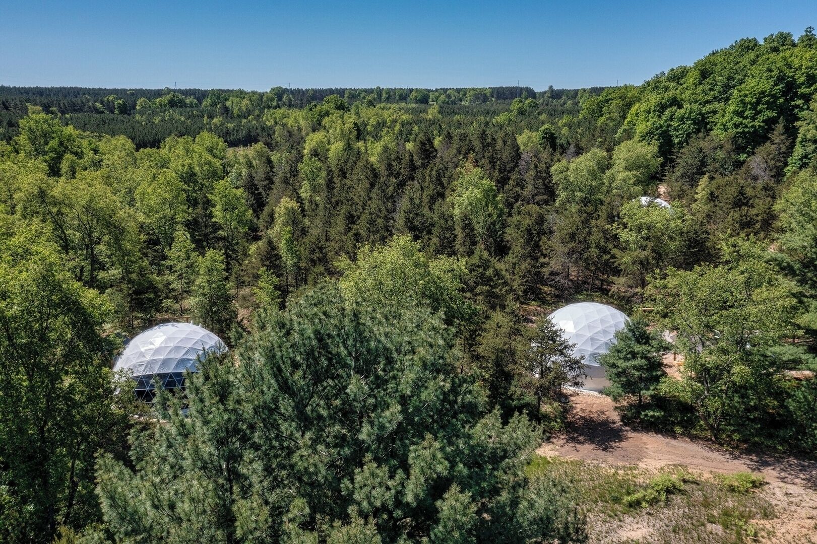 Two dome-shaped structures surrounded by dense forest.