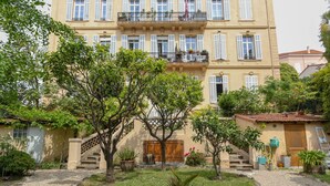A multi-story building with balconies, a staircase, and potted plants. - Modern apartment with 3 bedrooms, balcony, communal garden and A/C- Benakey (Cannes)