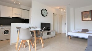 Un apartamento moderno con comedor, kitchenette, sala de estar y cama.