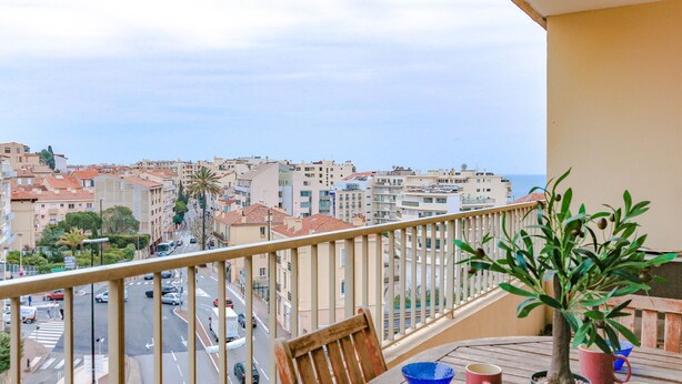 Un balcón con vista a la ciudad y al mar.