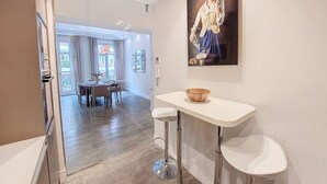 A modern kitchen with a dining area, a white countertop, and a painting on the wall. - N&J - VICTOIRE - Central - Near Beach (Niza)