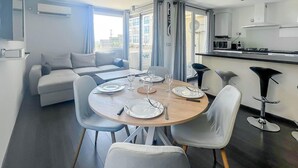 Un salon moderne comprenant un coin repas, un canapé et une cuisine équipée d’un four à micro-ondes.