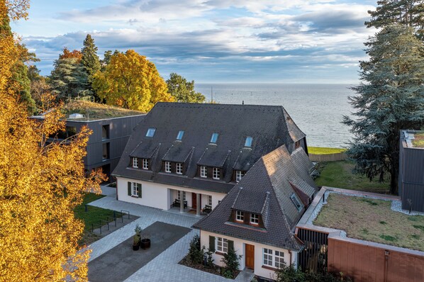 A modern house with a sloped roof, multiple windows, and a view of the sea. - Seegut Zeppelin – a member of Design Hotels (Friedrichshafen)