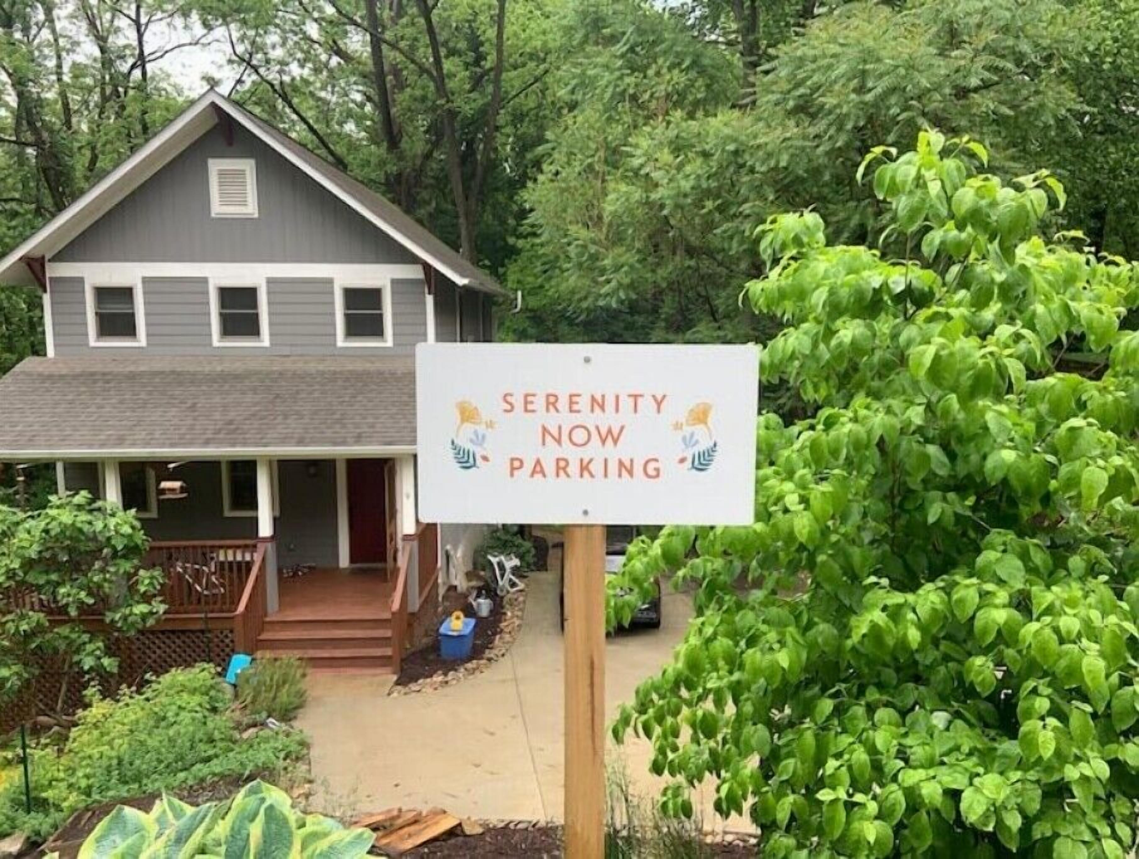 A house with a sign that reads "Serenity Now Parking".