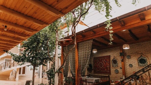 Un interior de madera tradicional con una escalera, un comedor y decoración mural.