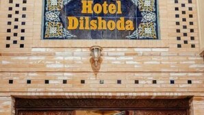 La entrada del Hotel Dilshoda, con puertas de madera decoradas y un cartel arriba.