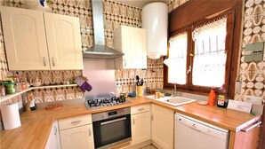 A kitchen with a gas stove, oven, dishwasher, and wooden countertops. - SAONA VILLAS (CP DOLORES) : villa 10 personnes, piscine privée, climatisation (Tres Calas)