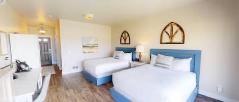 Ein Hotelzimmer mit zwei Betten, einem Schreibtisch und einem Stuhl.
