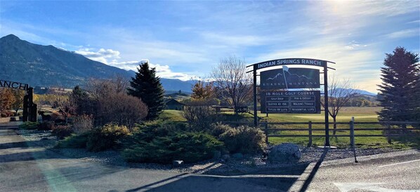 Señal de Indian Springs Ranch con servicios que incluyen un campo de golf, suites en ISR, senderos peatonales, parcelas para vehículos recreativos y terrenos residenciales.