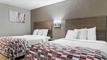 A hotel room with two beds, a large window, and a wall-mounted light fixture.