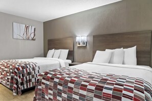 A hotel room with two beds, a large window, and a wall-mounted light fixture. - Red Roof Inn Flint (Flint)