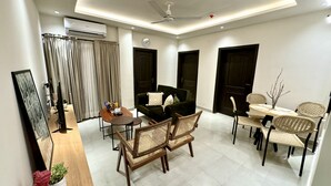 Uma sala de estar moderna com sofá, mesa de centro e área de jantar.