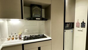 Uma cozinha moderna com fogão a gás, micro-ondas e frigorífico.