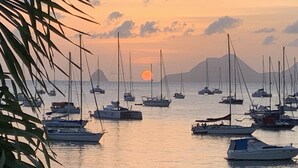 Ein Yachthafen mit mehreren Segelbooten, die im ruhigen Wasser bei Sonnenuntergang ankern.