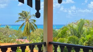 Ein Balkon mit Blick auf das Meer und Palmen.