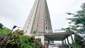 Un immeuble de grande hauteur sur lequel on peut lire l’inscription « TAMAN SAR PANORAMA ».
