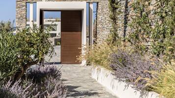 A modern building with a stone facade, a wooden door, and a pathway leading to it.