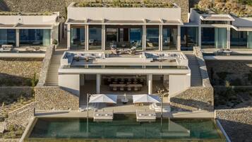Un resort moderno con piscina en la azotea, mobiliario exterior y un muro de contención de piedra.