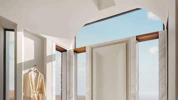 Un baño moderno con una bañera grande, una bata y vistas al mar.
