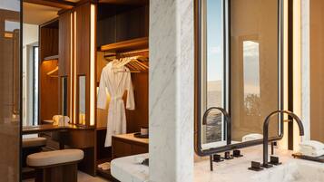 Bathroom features a large mirror, bench, and towel rack, offering a view of the surrounding desert landscape.