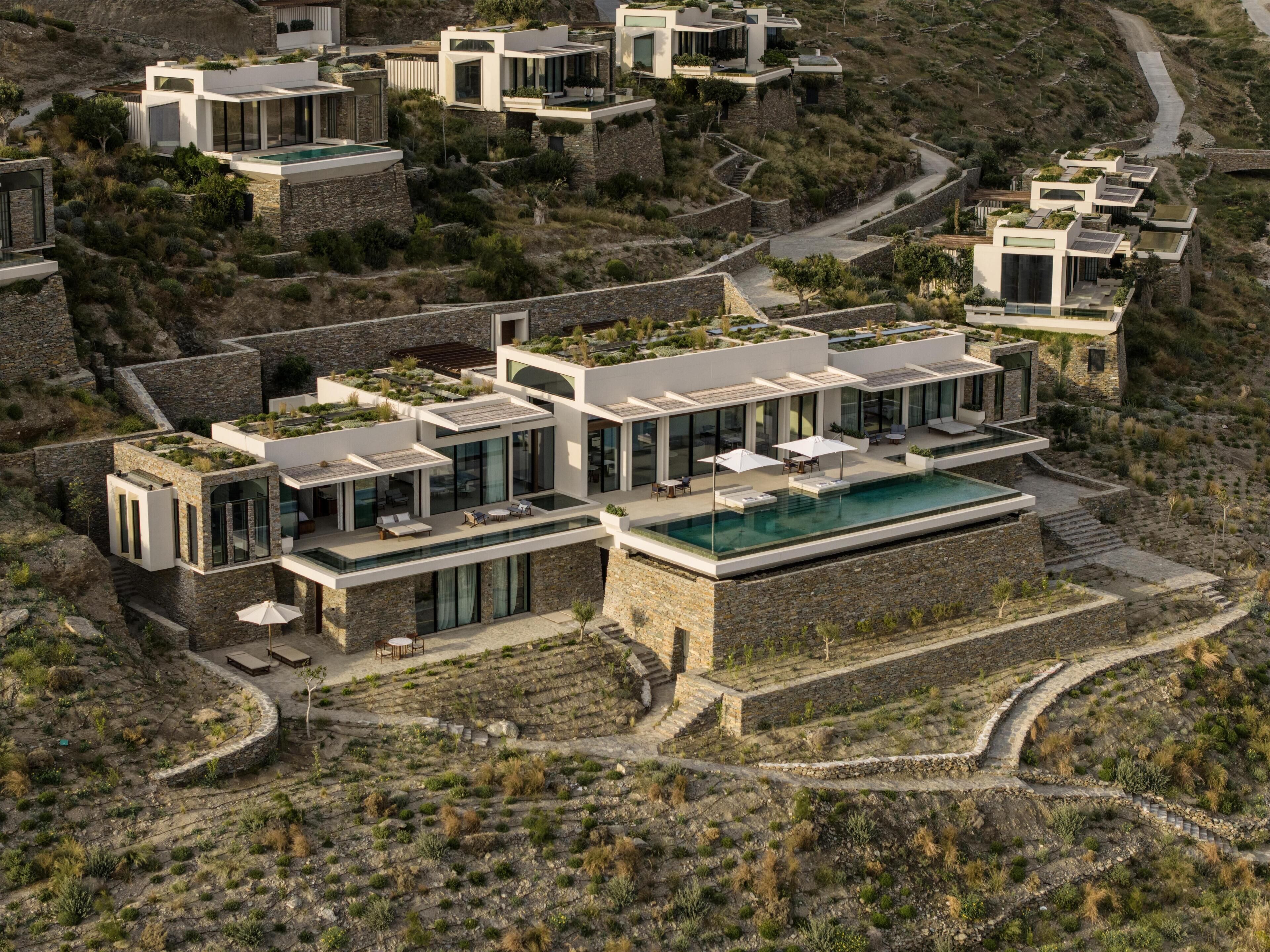 A modern residential complex with multiple houses, a central swimming pool, and terraced gardens.