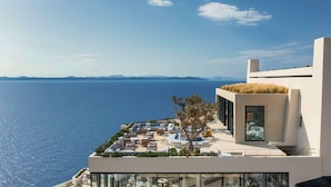 Ein modernes Hotel mit Dachterrasse und Blick aufs Meer.