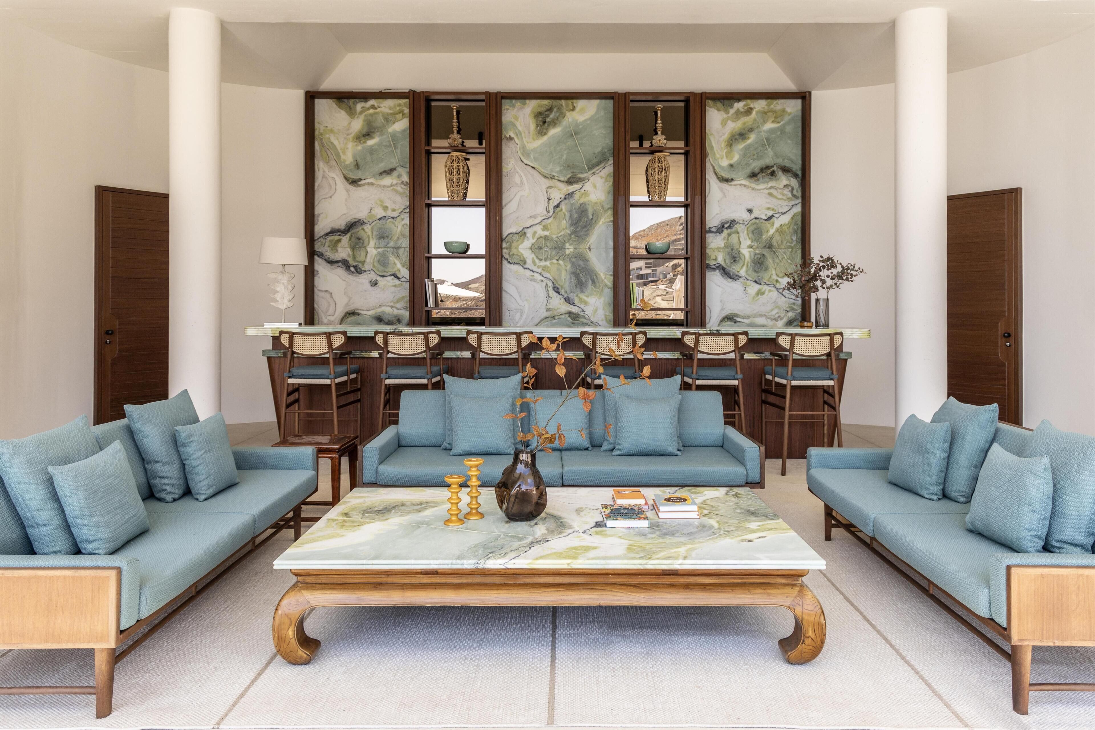 A living room with two sofas, a coffee table, and a large abstract painting on the wall.