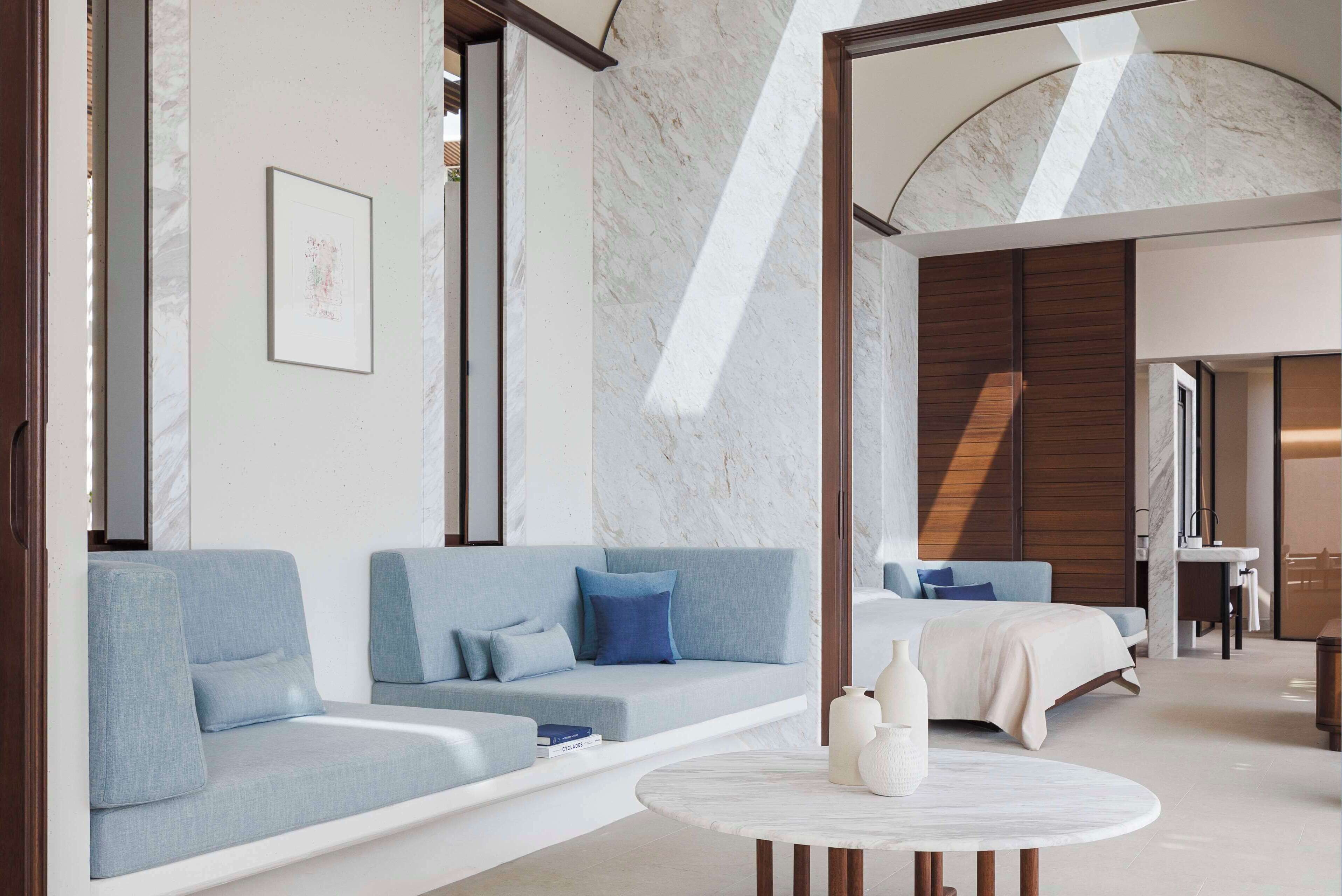 A modern interior with a sofa, a round table, and a bed.