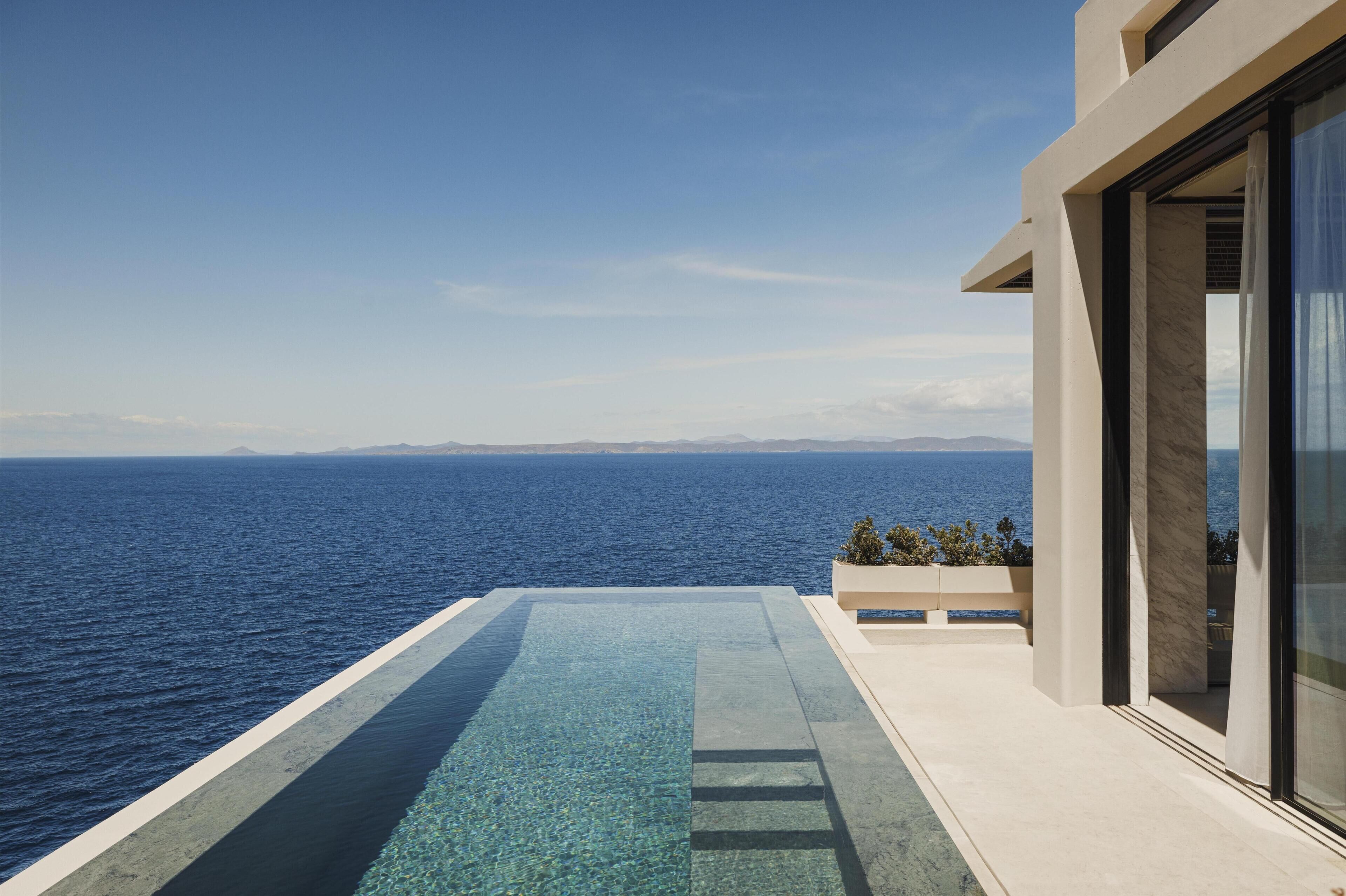 Un bâtiment moderne doté d’une piscine donnant sur un plan d’eau.