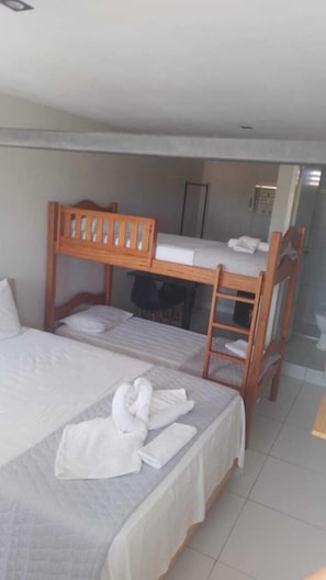 A room with two bunk beds, a wooden ladder, and a neatly made bed with a towel. - Bob Suites (Ipojuca)