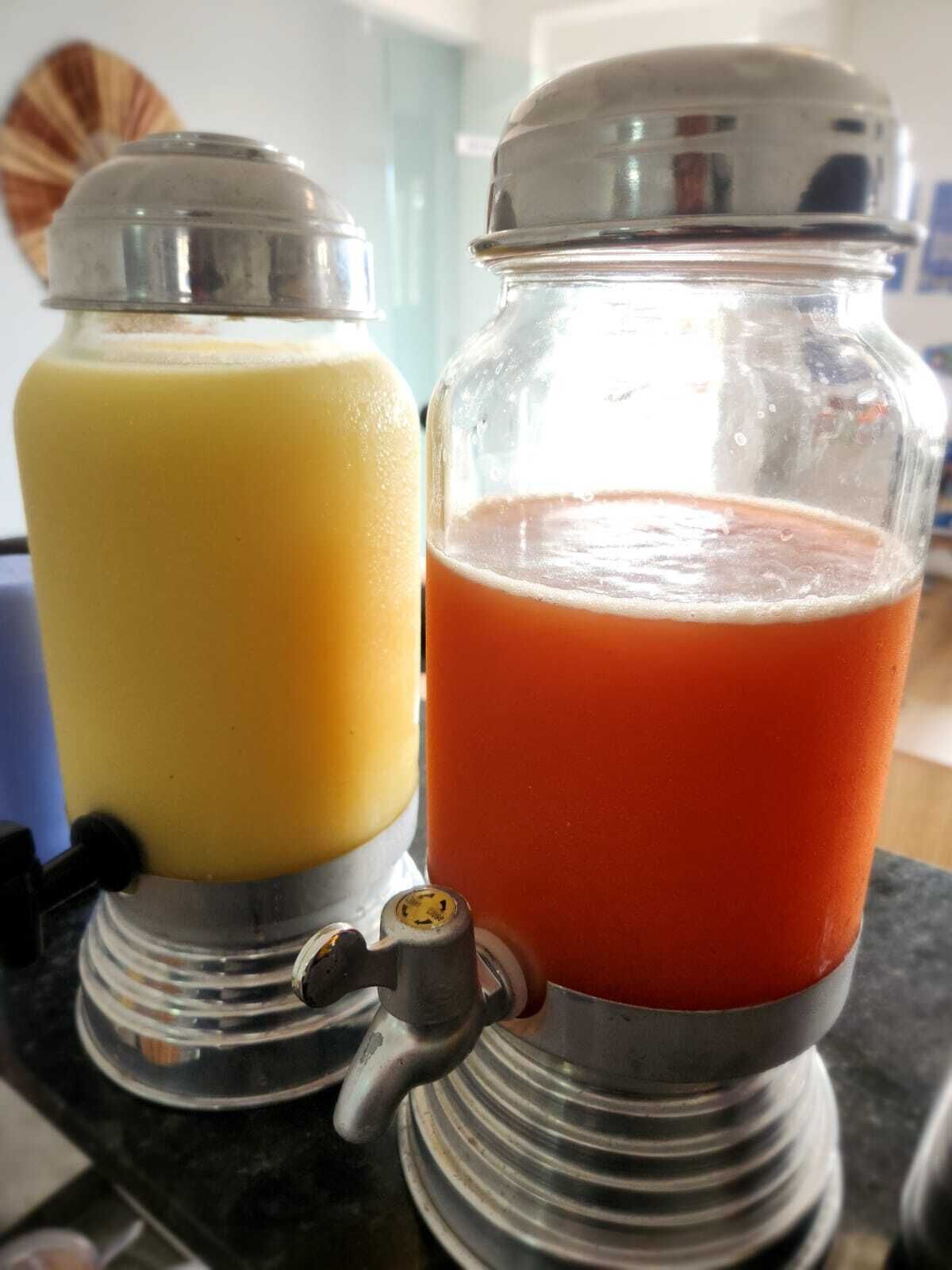 Dos dispensadores de vidrio sobre una encimera, uno con líquido amarillo y otro con líquido rojo.