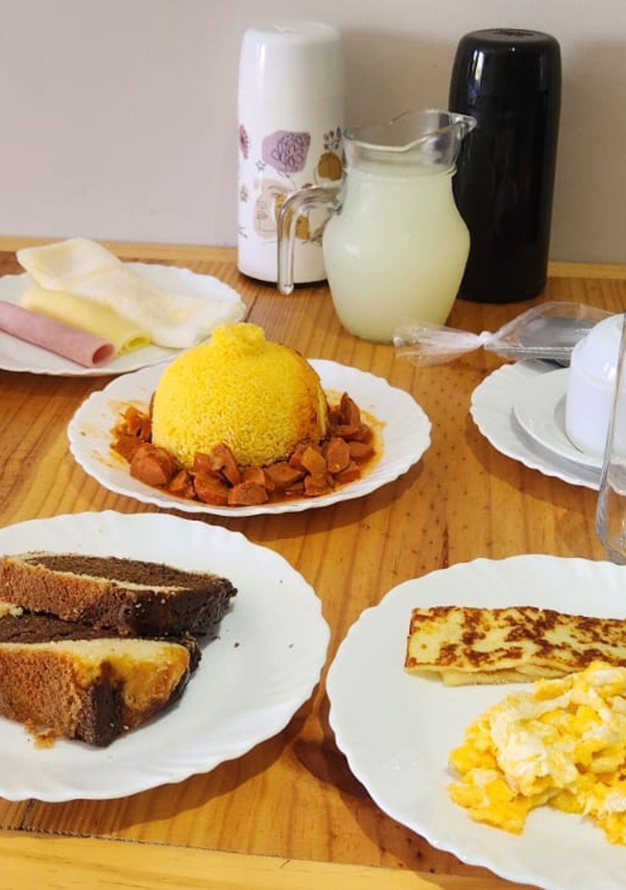 A table with plates of food, a pitcher, and a cup.