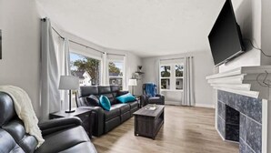A modern living room with a leather sofa, a coffee table, and a fireplace. - Blenheim Hideaway (Blenheim)
