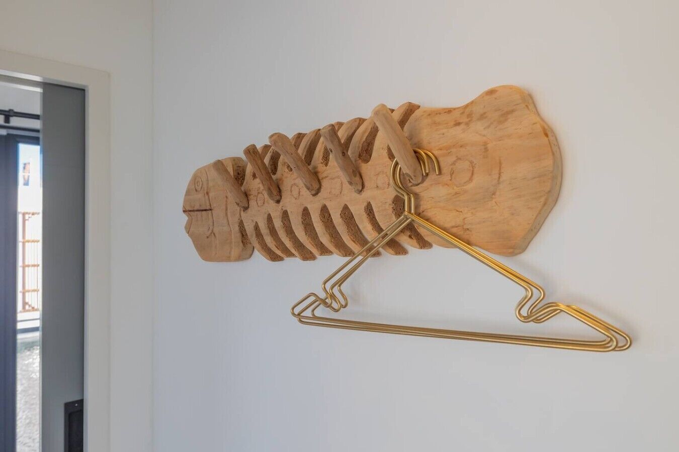 Eine an der Wand befestigte Holzskulptur mit Haken.