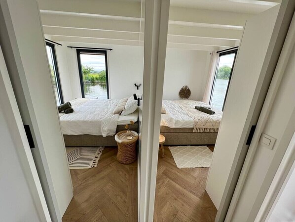Une chambre avec deux lits, une fenêtre et une vue sur l’extérieur.